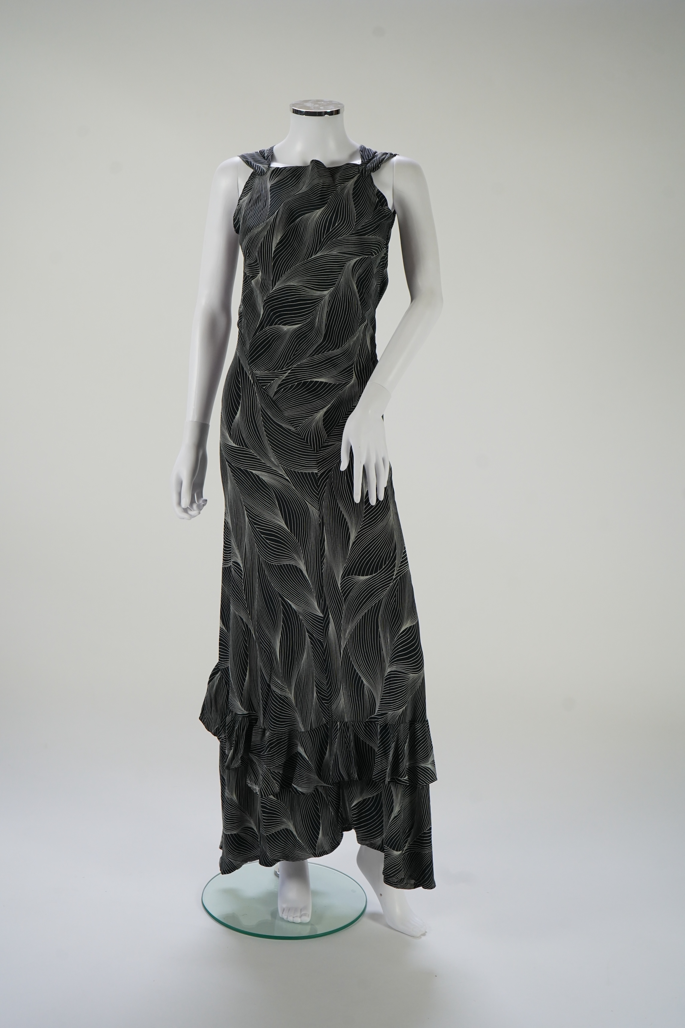 A 1930's black and silver halter neck, bias cut, ladies silk evening dress, designed with a loosely falling back and frills falling from the back of the dress to the front, bust bias cut 32-36 inches, length 57 inches fr